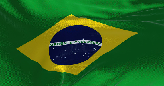 Close up of the national flag of Brazil on a waving flag. Curves and folds of the satin fabric with texture. Selective focus and depth of field. Democracy and politics. South american country.
