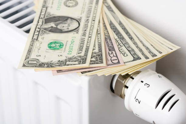 istock Dollar money banknotes on heating radiator battery with thermostat temperature regulator 1404655709