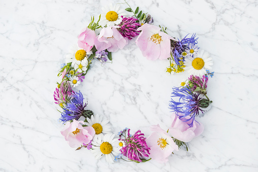 Floral arrangement, web banner with pink English roses, ranunculus, carnation flowers and green leaves on white table background. Flat lay, top view, wedding or birthday styled stock photography.