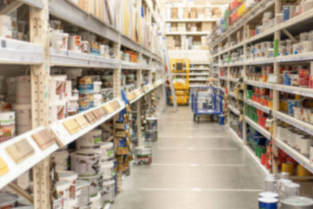 pasillo y racks con materiales de construcción y acabado en ferretería. vista de filas de hipermercados con pinturas, barniz e impregnación para madera. fondo borroso de compras y operaciones. - ferretería fotografías e imágenes de stock