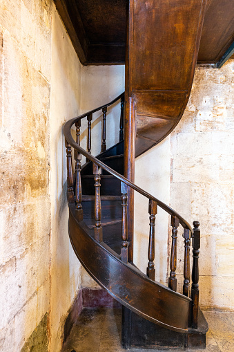 Classic vintage elegant wooden staircase with wrought iron railing.