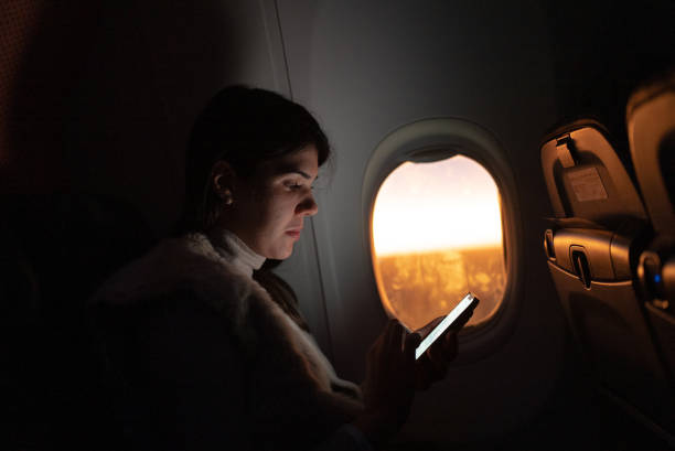 istock Woman traveling by plane and using mobile phone 1404663892