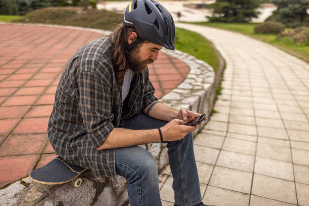 istock Urban male skateboarder using mobile phone 1404664227