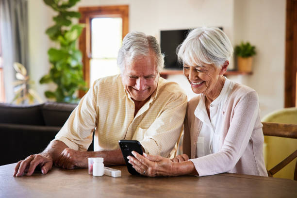 Senior couple talking during a video call with a doctor on a smart phone stock photo