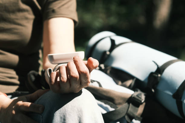 Female backpacker is measuring her blood pressure while hiking in forest