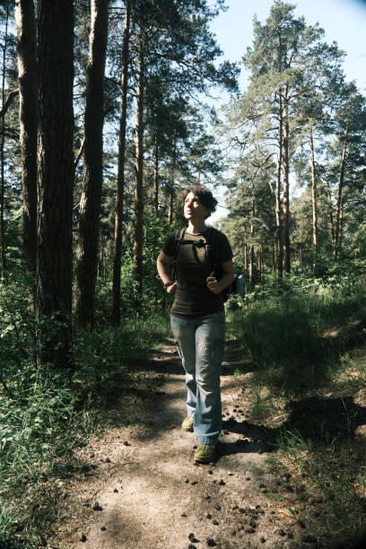 Female backpacker is hiking in forest