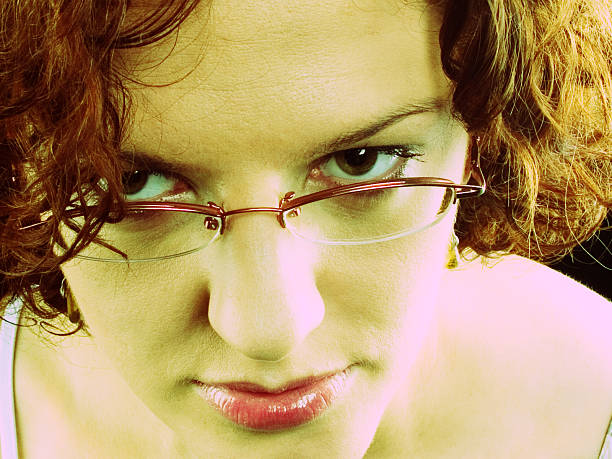 Young woman stares at your eyes. Cross-processed image.