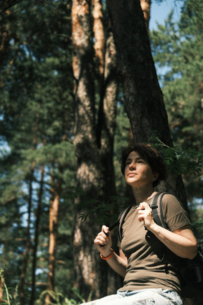 istock Female backpacker is resting on the stone while hiking in forest 1404666520