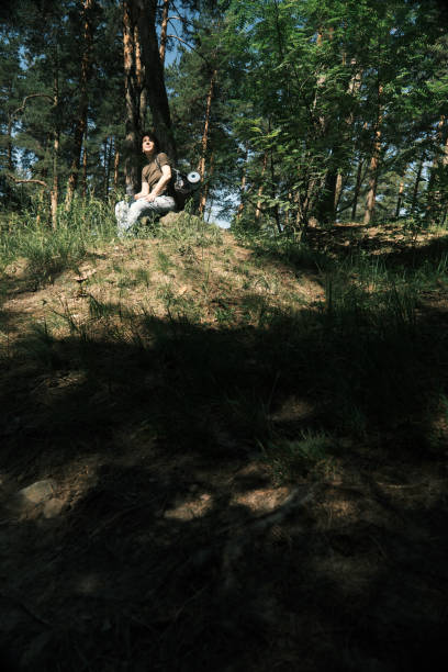 istock Female backpacker is resting on the stone while hiking in forest 1404666635