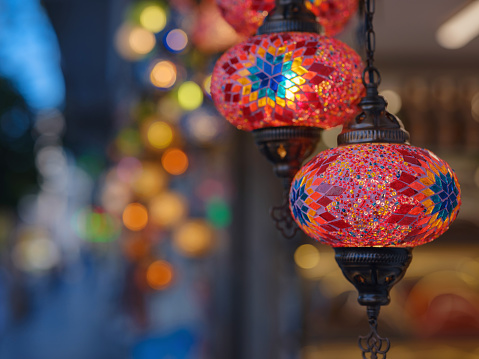 Colorful Turkish hanging lights of different colors and sizes. Turkish mosaic lambs. glass mosaic lamp in grand bazaar. Hand made mosaic vintage ottoman lambs and bokeh.