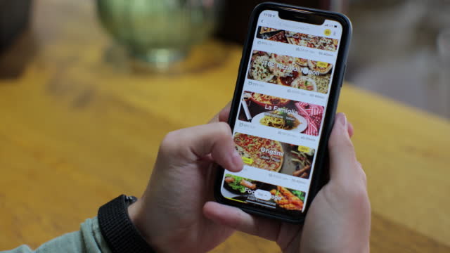 Ordering takeaway food online in a restaurant in a mobile app using a smartphone. Online delivery, online store, home delivery.