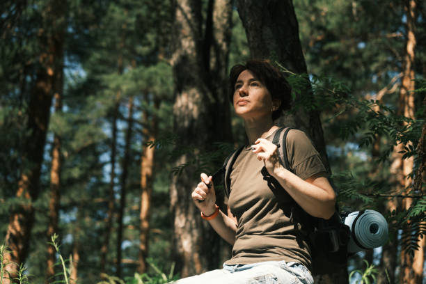 istock Female backpacker is resting on the stone while hiking in forest 1404666981