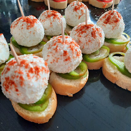 Canapes and mini sandwiches are served at a banquet table in a big restaurant.