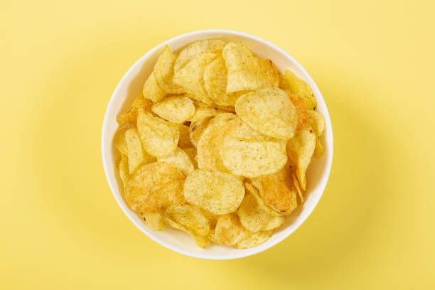 istock Potato chips in a bowl on yellow background 1404669969