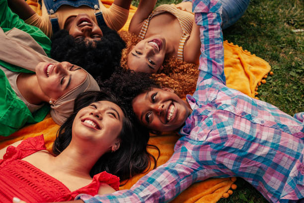 istock Friends lying on grass in park making circle 1404670446