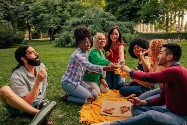 istock Friends in community park toasting with drink 1404670484