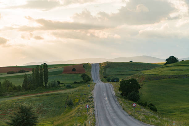 istock Empty asphalt road in rural landscape at sunset with dramatic clouds 1404672090