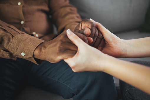 Closeup of a support hands. Closeup shot of a young woman holding a senior man's hands in comfort. Female carer holding hands of senior man