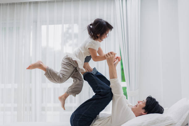 istock Little girl playing in bed with her daddy 1404672424