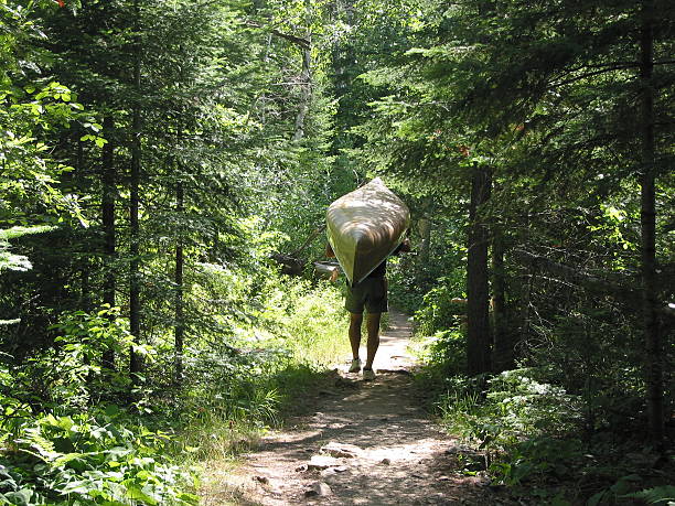 Portage through the Woods Portaging a canoe through woods in Boundary Waters Canoe Area, Minnesota. boundary waters canoe area stock pictures, royalty-free photos & images