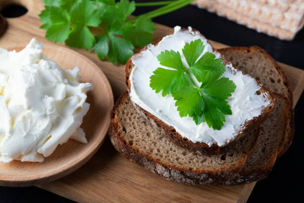 istock Home made bread on a wooden cutting board with curd cheese and ricotta 1404673119