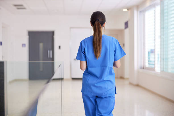 A nurse walks down the corridor in a hospital. stock photo