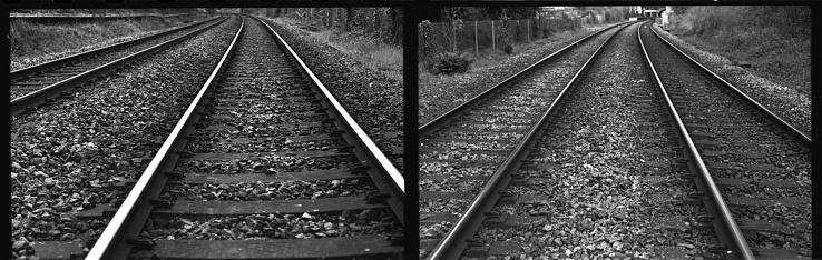 Two 35mm photos of traintracks leading in the opposite direction