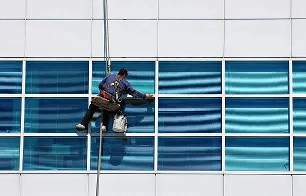 A man cleaning windows on a high-rise building