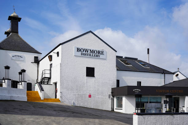 The Bowmore distillery on the Isle of Islay Bowmore, Islay, Scotland - May 14 2022: The Bowmore Scotch whisky distillery on the Isle of Islay. Bowmore is the oldest active distillery on the island. bowmore whisky stock pictures, royalty-free photos & images