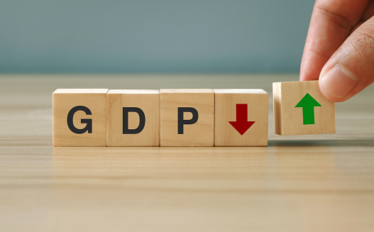 GDP. Symbol of gross domestic product.  Business and GDP growth. Gross domestic product concept.  GDP on a wooden block with arrows down and up