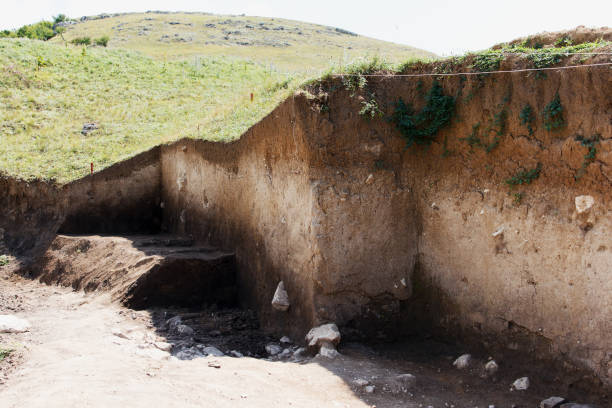 Archaeologists dug a hole on hillside to search for historical artifacts and finds stock photo