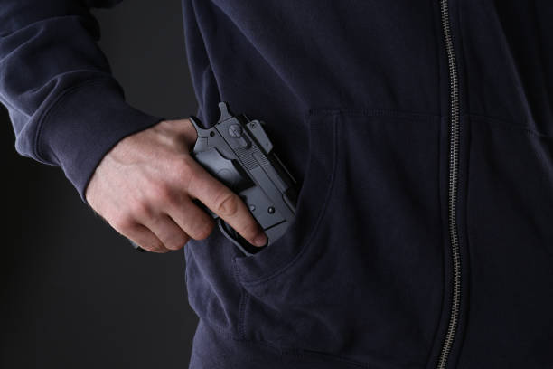 istock Man holding gun on black background, closeup 1404683893