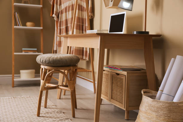 istock Comfortable wooden stool near table with laptop indoors. Interior design 1404684934