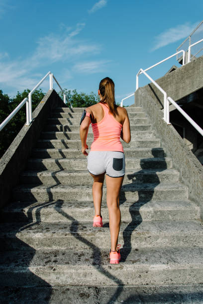 istock Woman running and climbing stairs 1404686100