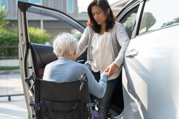 Asian senior or elderly old lady woman patient sitting on wheelchair prepare get to her car, healthy strong medical concept. Asian senior or elderly old lady woman patient sitting on wheelchair prepare get to her car, healthy strong medical concept. senior adult car nurse physical impairment stock pictures, royalty-free photos & images