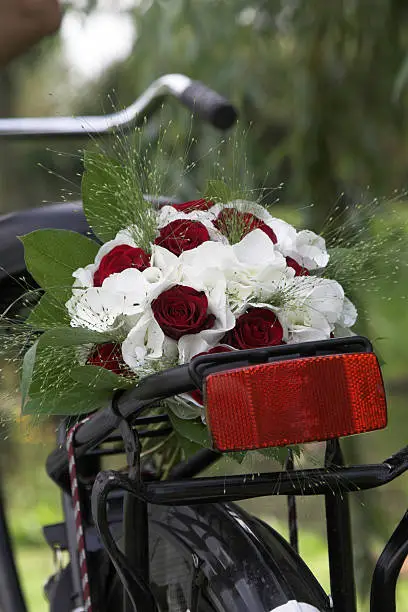 Weddingbouquet has been tied to the back of the bicycle