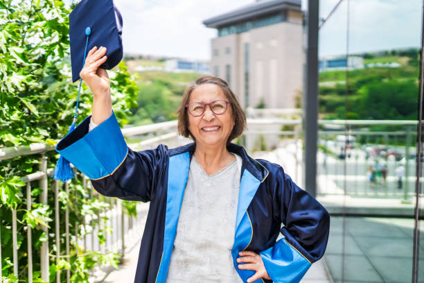 une femme âgée heureuse et fière diplômée de l’université - women professor mature adult human face photos et images de collection