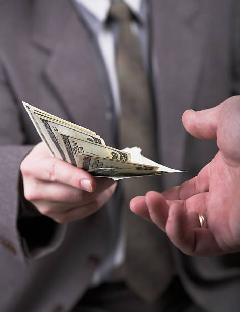 istock man in suit giving dollars 140468946