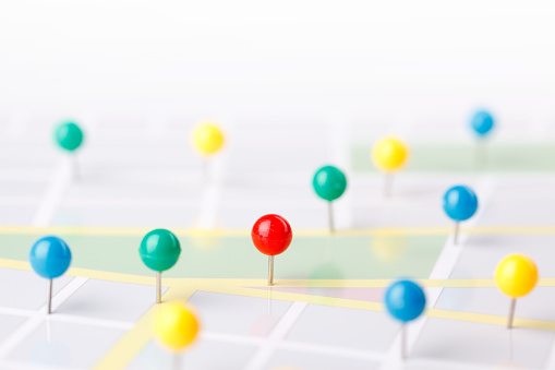 Colorful pushpins on a city map.