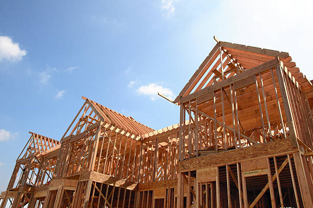 House Wooden Frame Wooden frame of a new house under construction against a bright sunny sky american architecture stock pictures, royalty-free photos & images