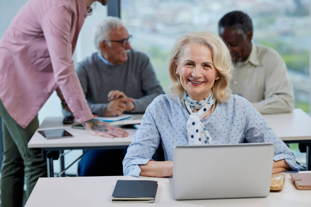 istock A senior female student typing on the laptop school assignment while smiling at the camera. 1404693207