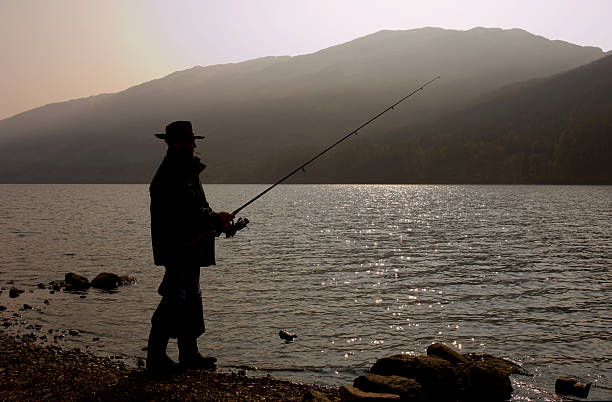 Fishing at dawn Fishing at dawn on Loch Voil near Balquhidder in the central highlands of Scotland. loch voil stock pictures, royalty-free photos & images