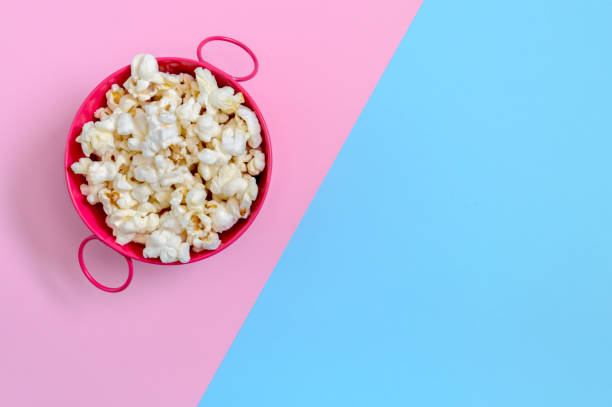 istock Bowl of popcorn on a bicolor background with copy space. Top view. 1404696515