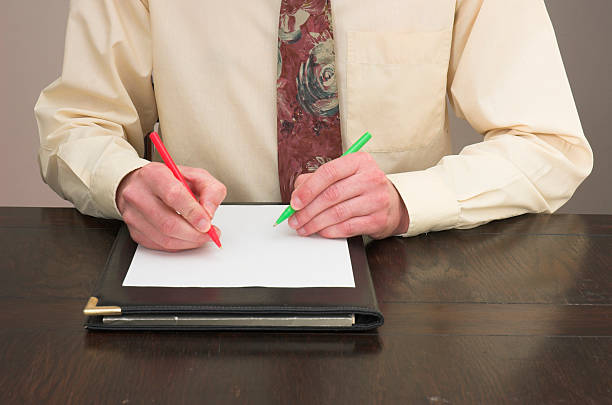 Clever writing Man working at desk with pens in both hands! ambidextrous stock pictures, royalty-free photos & images