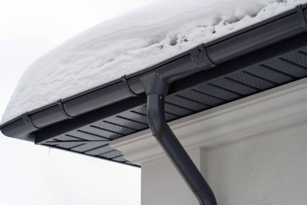 istock Metal Downpipe system, Guttering System, External downpipes and drainage pipes under snow. Corner of house with roof made of gray metal tiles and gutter covered with thick layer of snow in winter. 1404700597