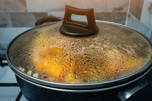Drops of condensate on the lid of the frying pan in which the stew is stewed. The concept of new recipes for homemade dishes
