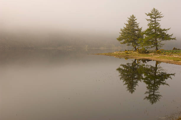 Misty Loch Voil The morning mist starting to clear over Loch Voil near Balquhidder in Perthshire Scotland. loch voil stock pictures, royalty-free photos & images