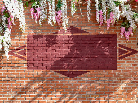 Full frame red brick wall detail with sunlight and flowers