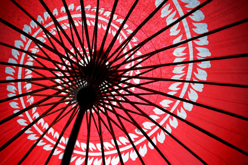 Underneath the Japanese traditional red umbrella with with floral motives