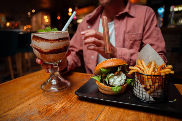istock Friends out for dinner eating burger and milkshake 1404710187